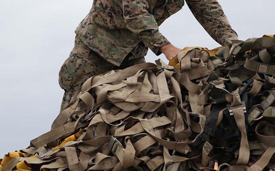 Chief Warrant Officer Allen T. Leiper uses cargo nets to secure palletized equipment Nov. 11 at Marine Corps Air Station Futenma, Okinawa, Japan. The equipment was later loaded onto a KC-130J Hercules aircraft to be used during humanitarian assistance and disaster relief operations in the Philippines in the aftermath of Typhoon Haiyan. 