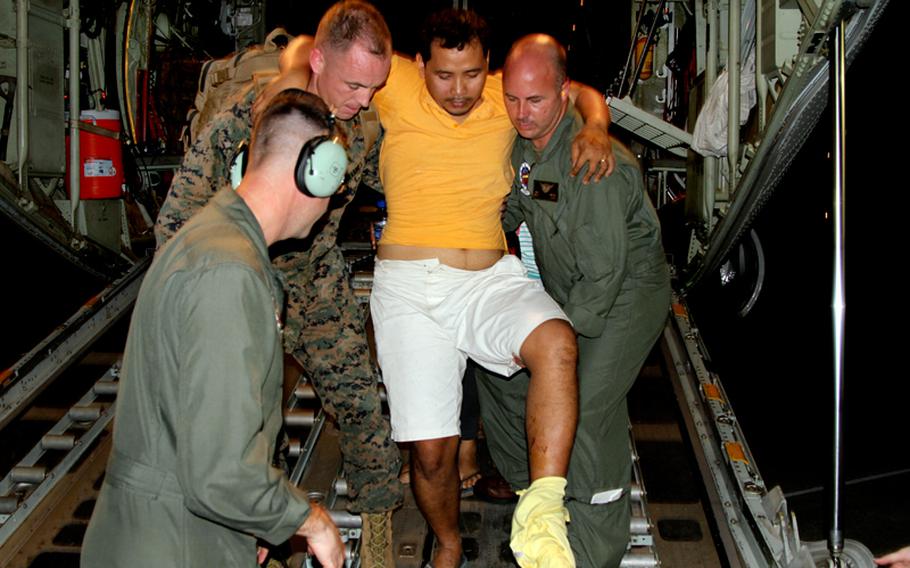 U.S. Marines carry an injured Filipino man off the back of a KC-130J Super Hercules at Villamor Air Base, Manila, the Philippines, on Monday, Nov. 11, 2013. Defense Secretary Chuck Hagel directed Marines to provide humanitarian relief after Typhoon Haiyan devastated parts of the country.