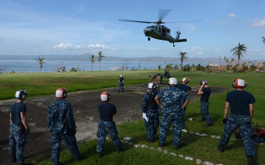 US troops wait for a Seahawk helicopter from the USS Mustin to land at Ormoc City, Philippines, during relief efforts after Typhoon Haiyan, Nov. 17, 2013.