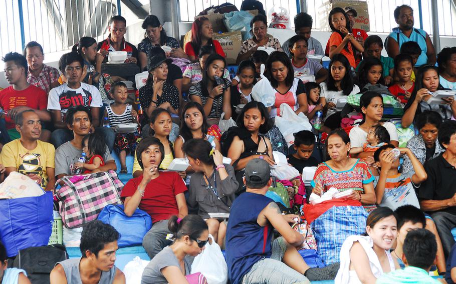 Evacuees eat Wednesday afternoon at the open-air stadium at Villamor Air Base shortly after arriving at the Manila air base from Tacloban. The U.S. military has flown thousands of evacuees to Villamor since Typhoon Haiyan. 