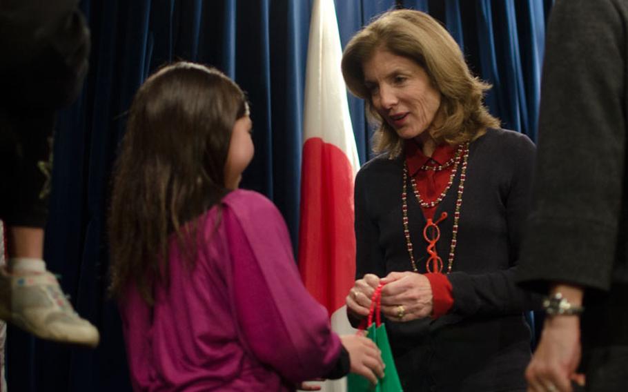 YOKOTA AIR BASE, Japan -- US Ambassador to Japan Caroline Kennedy receives a gift from a young girl whose father is stationed at Yokota Air Base during a visit to the base Nov. 21, 2013. Kennedy toured both US Air Force and Japan Air Self Defense Force facilities while in Yokota.   