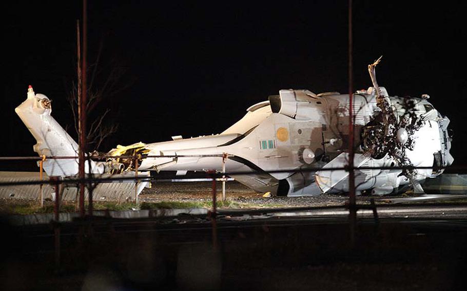 The wreckage of a U.S. Navy Knighthawk helicopter sits where it crash-landed in an empty area about 10 miles southwest of Yokosuka Naval Base on Monday, Dec. 16, 2013.