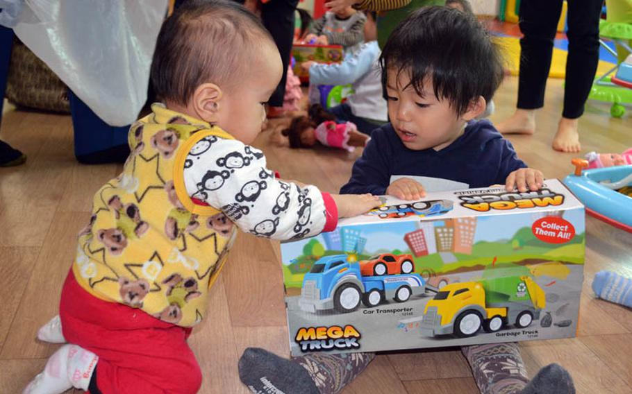 A couple of children happily receive toys at Jacob's House orphanage, Pyeongtaek, South Korea, Dec. 22, 2013. Over 300 toys were donated by U.S. military personnel stationed in South Korea. 