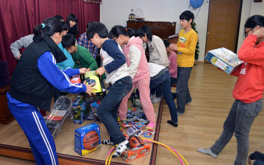 Children from Dream-Up Home orphanage select donated toys at Suwon, South Korea, on Dec. 22, 2013. U.S. Marine Maj. Bryon deCastro led the Toys for Tots donation drive held at Osan Air Base. 