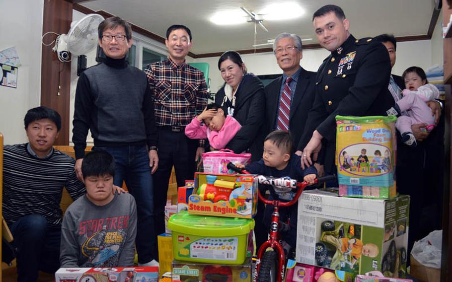 U.S. Marine Maj. Bryon deCastro, far right, Christina JuYong Park, center, and Peter Park, far left, stand with stand with the children and providers at Baby Box orphanage, Seoul, South Korea, on Dec. 22, 2013. The three helped deliver toys donated by U.S. military personnel in South Korea. 