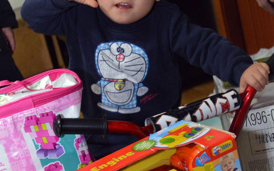 A South Korean child gives a salute to U.S. Marine Maj. Bryon deCastro, Christina JuYong Park and Peter Park for delivering toys to Baby Box orphanage at Seoul, South Korea, on Dec. 22, 2013. The three helped deliver toys donated by U.S. military personnel in South Korea. 