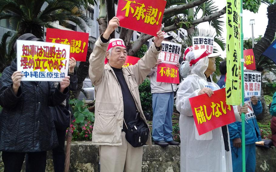 About 1,500 people rally Tuesday in front of the Okinawa prefectural government office to urge Gov. Hirokazu Nakaima to turn down a request from Tokyo to reclaim waters off Henoko in Nago to build a new runway for the Marine Corps base.