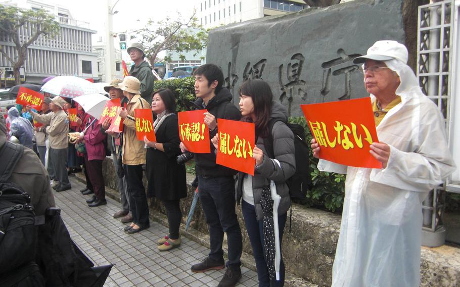 About 1,500 people Tuesday surround the Okinawa prefectural government office, urging Gov. Hirokazu Nakaima to disallow a landfill request from Tokyo to build a new Marine Corps runway off shore from Camp Schwab.