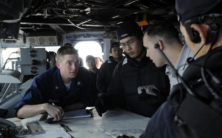 Petty Officer 3rd Class Philip Horsley talks with members of the Japan Maritime Self-Defense Force aboard the USS Blue Ridge during Exercise Malabar 2009. The Japanese are asking to be included in Malabar, which has been only a bilateral exchange between the United States and India in more recent years.