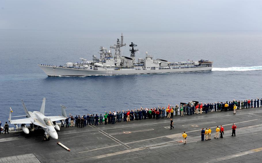 Sailors aboard the USS Carl Vinson aircraft carrier wave to the Indian Navy destroyer INS Ranvijay during the annual Exercise Malabar, April 16, 2012.