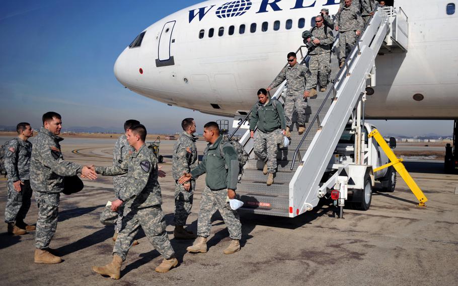 Senior leaders of the 2nd Infantry Division greet members of the 1st Battalion, 12th Cavalry Regiment as they arrive at Osan Air Base, Republic of Korea, Jan. 29, 2014.