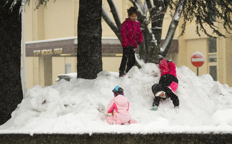 Children at Yokota Air Base near Tokyo enjoy the day off from school in front of the base medical clinic Friday, Feb. 14, 2014. A second winter storm in as many weeks was projected to leave as much as 12 inches of snow by the end of the day.