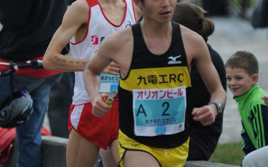 Runners enter the base during on of the final stretches of the Okinawa Marathon at Kadena Air Base, Okinawa, Feb. 16, 2014. 