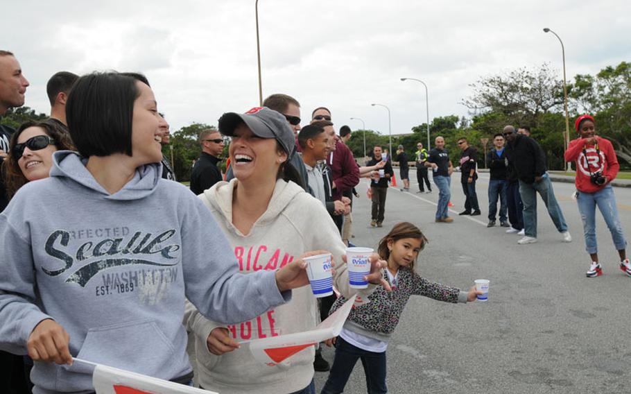Volunteers stand ready with cups of water for runners during the Okinawa Marathon at Kadena Air Base, Okinawa, Feb. 16, 2014. 