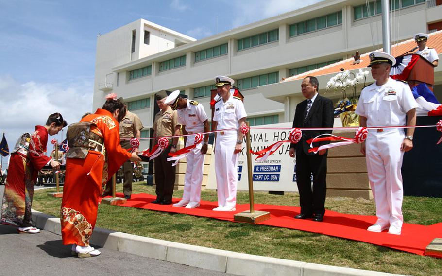 Marines, sailors and guests are presented scissors for a ribbon-cutting ceremony April 30, 2013, at U.S. Naval Hospital Okinawa on Camp Foster. The hospital had been located on Camp Lester since 1958.
