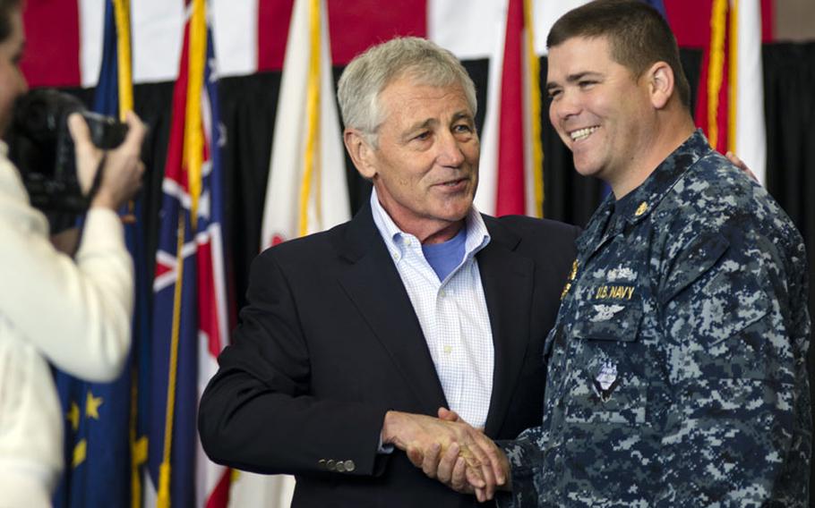 Secretary of Defense Chuck Hagel coins a Navy Chief Petty Officer after giving a speech to US and Japanese soldiers, sailors, Marines and airmen stationed in the Tokyo area at Yokota Air Base, Japan April 5, 2014. Hagel also provided a brief Q&A about sequestration, force management and base closures. 