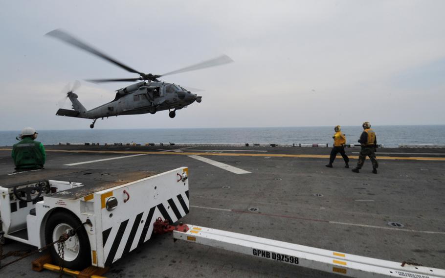 A MH-60 Sea Hawk helicopter takes off from the flight deck of the Bonhomme Richard to assist in search and rescue operations for the sunken ferry Sewol in South Korean waters, April 20, 2014.