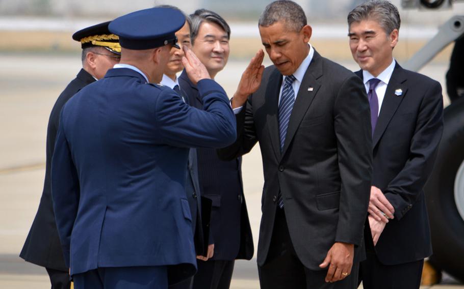 President Barack Obama returns a salute to Air Force Col. Brook J. Leonard, 51st Fighter Wing commander, at Osan Air Base, South Korea, on Friday, April 25, 2014.