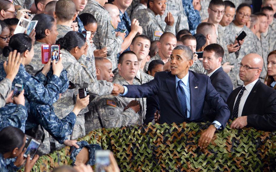 President Barack Obama shakes the hand of a soldier as troops take photos of him at Yongsan Garrison, South Korea, on Saturday, April 26, 2014. Obama's speech capped his 2-day tour of the country prior to departing for Malaysia.