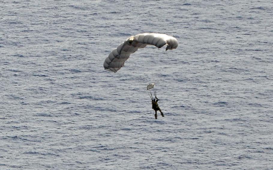 A pararescue airman from the 48th Rescue Squadron parachutes into the Pacific Ocean to aid 2 critically injured sailors aboard a Venezuelan fishing boat May 3, 2014.