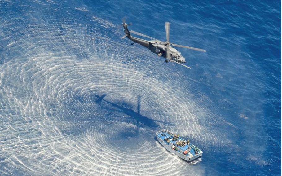 A Pave Hawk helicopter hovers above a skiff used to hoist the injured Chinese fishermen from their location about 600 miles off the Mexico coast, May 5, 2014.