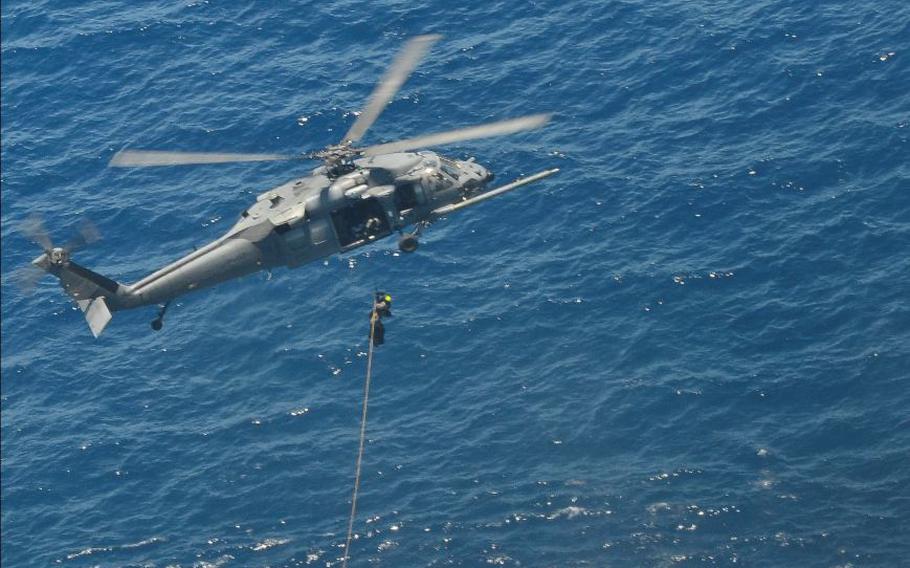 A Pave Hawk helicopter hoists a pararescue airman and an injured Chinese fisherman from their location about 600 miles off the Mexico coast, May 5, 2014.