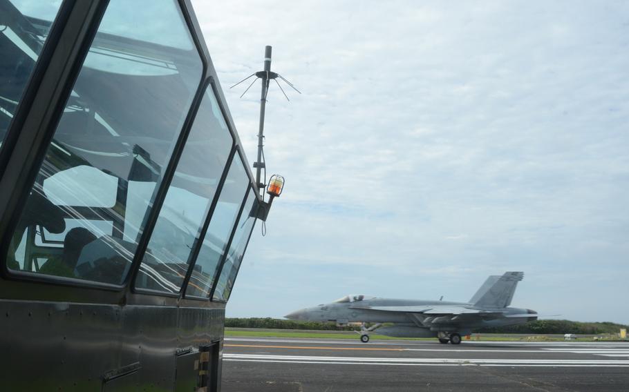 Landing signal officers inside the booth grade the landing executed by an F-18 pilot during field carrier landing practice at Iwo To, formerly known as Iwo Jima, on May 14. 
