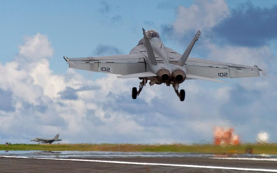 An FA-18/F Super Hornet performs touch and go flight operations on the island of Iwo Jima on Oct. 16, 2007, during a field carrier landing drill used to simulate landing jets on aircraft carriers at sea. The jet was with a Navy unit forward deployed to Naval Air Facility Atsugi, Japan.