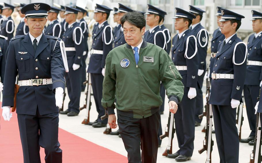 Japan's Defense Minister Itsunori Onodera, center, reviews honor guard ahead of a commemoration ceremony to mark the 60th anniversary of the foundation of Japan Air Self-Defense Force, in Irima, near Tokyo Sunday, May 25, 2014.