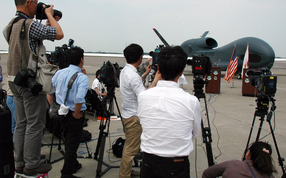 Japanese journalists photograph a Global Hawk at Misawa Air Base, Japan on Friday. Japanese officials and journalists were invited to the base to see the large unmanned drone, which will call Misawa home for the next six months.