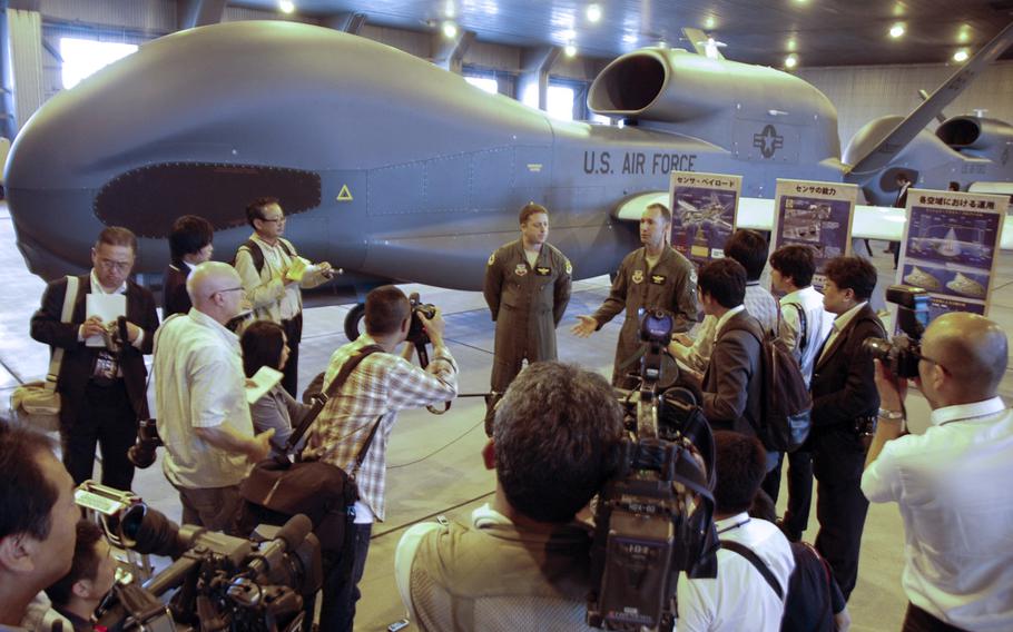 Drone pilots from Detachment 1, 69th Reconnaissance Group talk to Japanese reporters about the Global Hawk surveillance plane at Misawa Air Base, Japan, on Friday. 