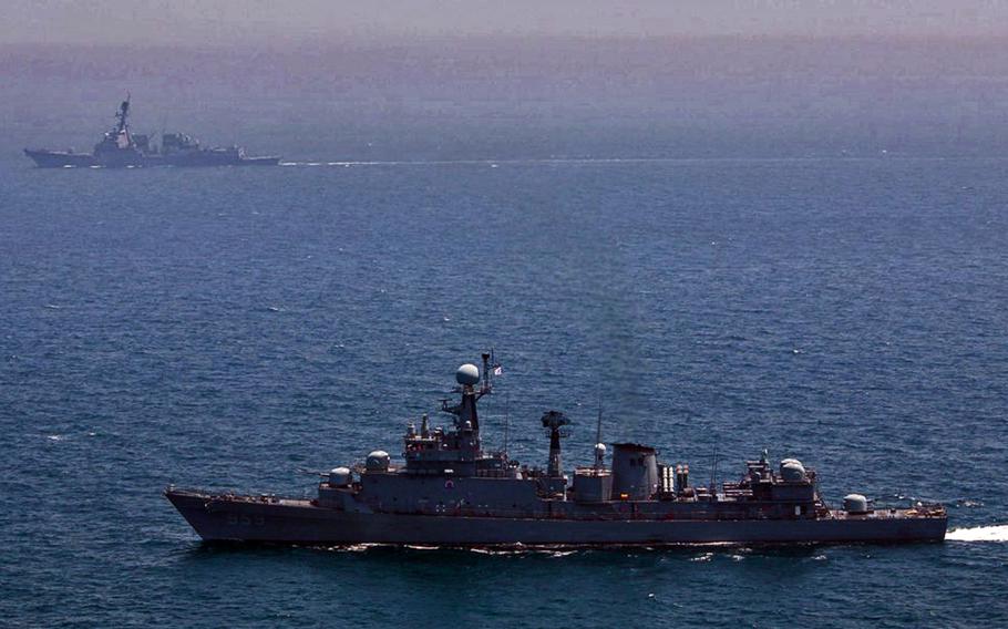The South Korean Ulsan-class frigate Busan, foreground, conducts maneuvers Saturday, May 31, 2014, with the Arleigh Burke-class guided-missile destroyer USS Wayne E. Meyer off the southern coast of South Korea.