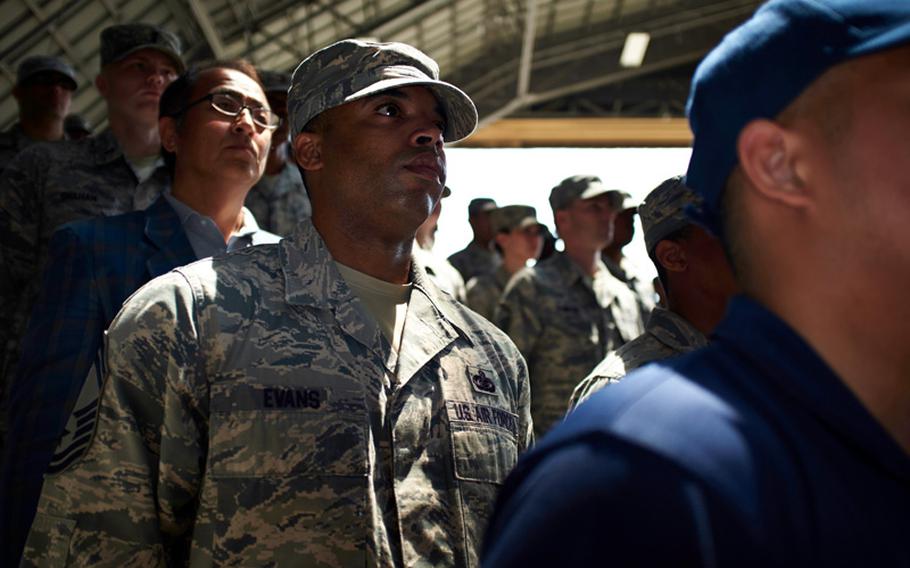 An airman from the 374th Airlift Wing stands at attention during the wing's change of command ceremony June 26, 2014, at Yokota Air Base, Japan. Air Force Col. Douglas C. Delamater relieved Col. Mark "Buzz" August as commander of the US military's only airlift wing in the Pacific.