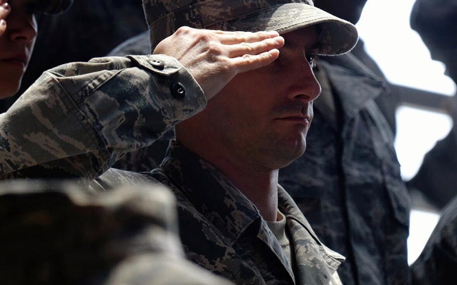 An airman from the 374th Airlift Wing salutes during the wing's change of command ceremony June 26, 2014, at Yokota Air Base, Japan. Air Force Col. Douglas C. Delamater relieved Col. Mark "Buzz" August as commander of the US military's only airlift wing in the Pacific.