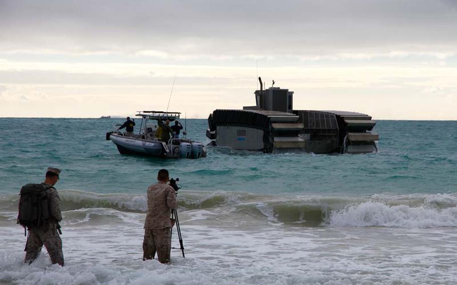 Civilian and military camera operators swarm to get images of the prototype Ultra Heavy-lift Amphibious Connector amphibious craft being tested by the Marines in Hawaii on Friday, July 11, 2014.