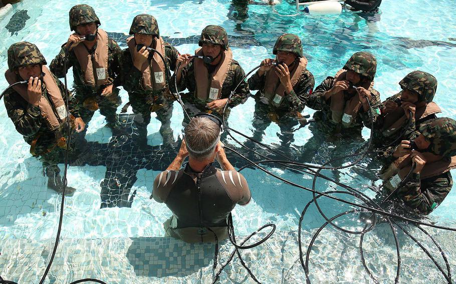 Members of the Mexico Naval Infantry Force learn to breathe compressed air during shallow water egress training at the Marine Corps Base Hawaii pool during RIMPAC, July 1, 2014. 