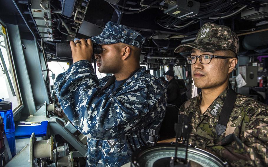 Ensign Darien Sears, from Spring Valley, Maryland, left, assigned to the Arleigh Burke-class guided-missile destroyer USS Kidd (DDG 100), stands watch with Republic of Korea navy Lt. Donghoon Lee during bilateral operations. Kidd is currently on patrol in the U.S. 7th Fleet area of responsibility supporting regional security and stability in the Indo-Asia Pacific region. 