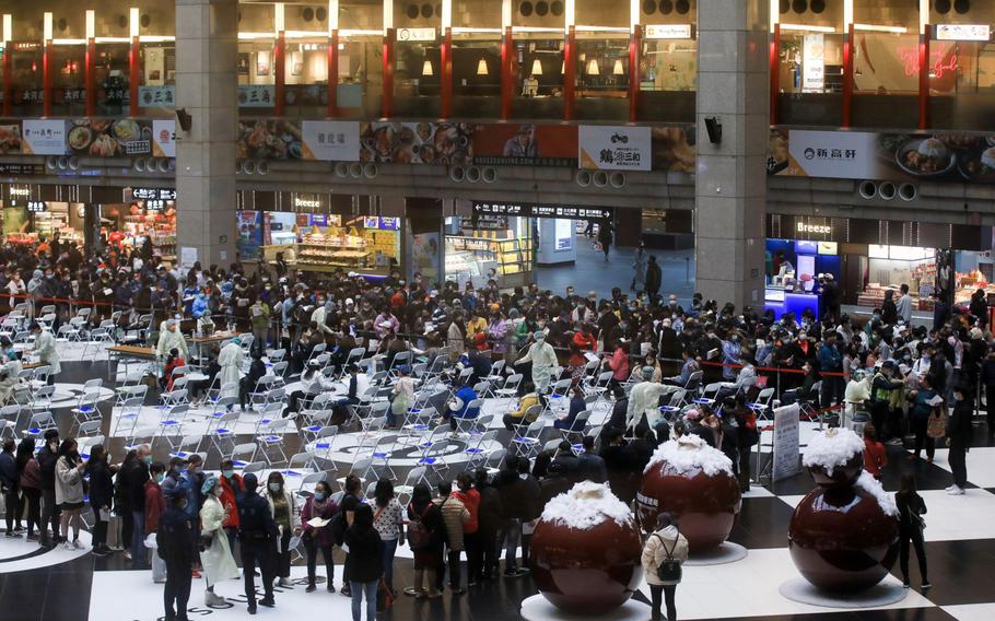 Members of the public wait in line at a vaccination facility administering the Moderna Covid-19 vaccine set up at Taipei Main Station in Taipei, Taiwan, on Jan. 17, 2022. 