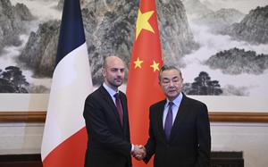 Two men shake hands inside a building in China.