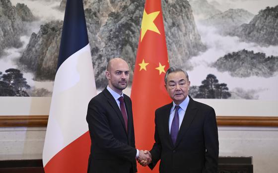 Two men shake hands inside a building in China.