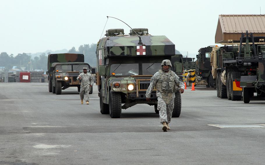 Troops and vehicles move along a staging area on Camp Humphreys, South Korea, during Exercise Ulchi Freedom Guardian 2014.