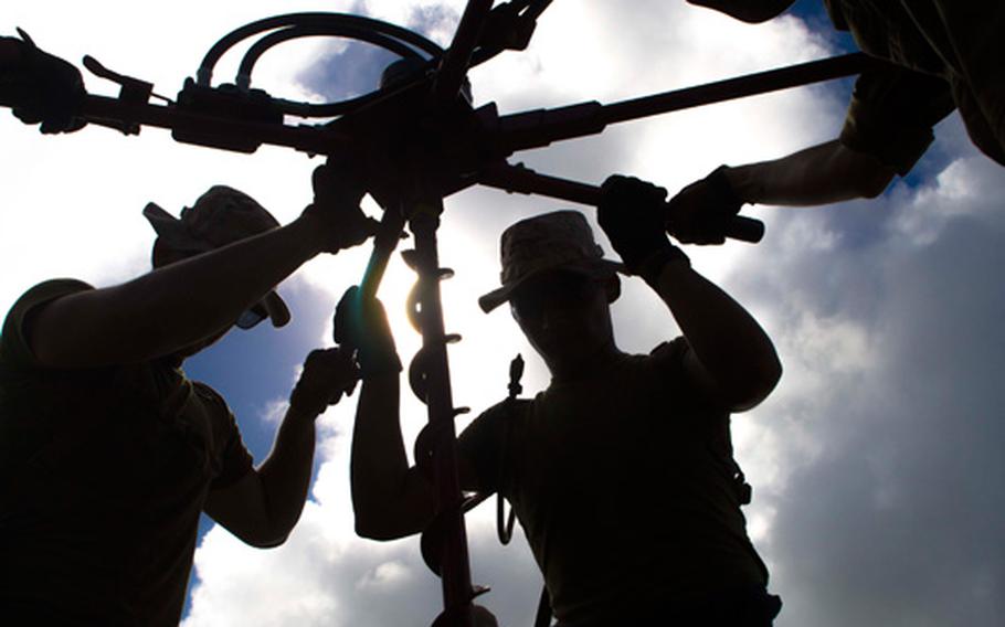 Marines with Marine Wing Support Squadrons 171 and 172, both currently assigned to Marine Aircraft Group 12, 1st Marine Aircraft Wing, III Marine Expeditionary Force, drill a hole into the ground as part of the M31 Marine Corps expeditionary arresting gear system in preparation for Valiant Shield 2014. Arresting gear is used to stop aircraft quickly in case they land on a short runway or experience an emergency. 