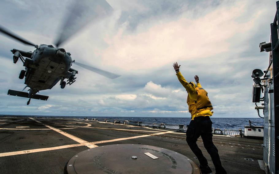 Boatswain's Mate 3rd Class Tyler Joosten from Salt Lake City, Utah, signals an MH-60S Sea Hawk from the Golden Falcons of Helicopter Sea Combat Squadron 12 as it launches from the flight deck of the Arleigh Burke-class destroyer USS Halsey. Halsey is currently participating in Valiant Shield, a U.S.-only exercise integrating U.S. Navy, Air Force, Army and Marine Corps assets, offering real-world joint operational experience to develop capabilities that provide a full range of options to defend U.S. interests and those of its allies and partners. 