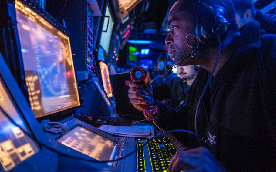 Petty Officer 2nd Class Omar Murrell, from Houston, assigned to the Arleigh Burke class guided missile destroyer USS Mustin, stands watch in the ship's combat information center during Valiant Shield 2014. 
