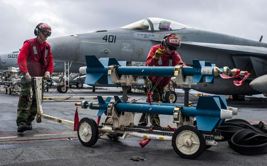 Sailors transport ordnance on the flight deck of the forward deployed aircraft carrier USS George Washington as part of Valiant Shield 2014.