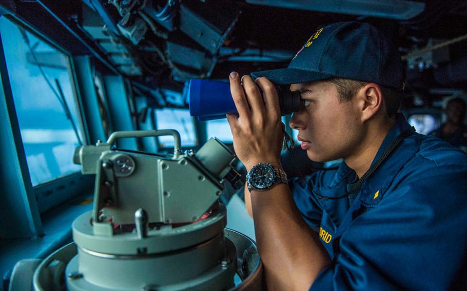 Ensign Michael Madrid, assigned to the Arleigh Burke-class guided-missile destroyer USS Mustin, scans the horizon during a replenishment-at-sea during Valiant Shield 2014. 