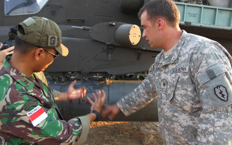 U.S. Army Sgt. Dale Morrell, a technical inspector, describes some of the features of the Apache attack helicopter to 1st Lt. Albert Taroreh, a flight engineer with the Indonesian army. Aviators and flight crews from the two countries spent weeks together training during Garuda Shield on Java Island, which concludes at the end of September.
