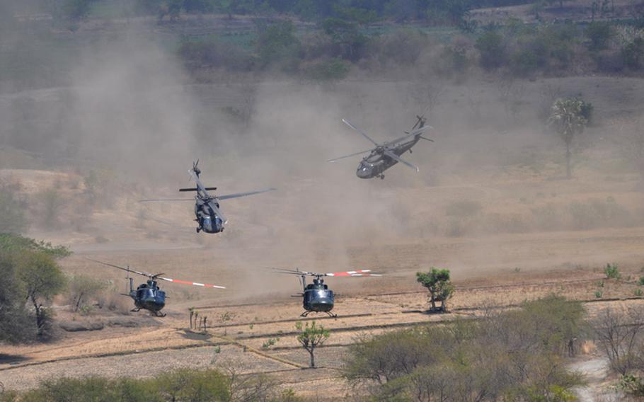 Indonesian and American helicopters churn up dust during the final live-fire assault that culminated the Garuda Shield exercise in Indonesia in September. The joint national assault included Apaches, Blackhawks and Strykers.