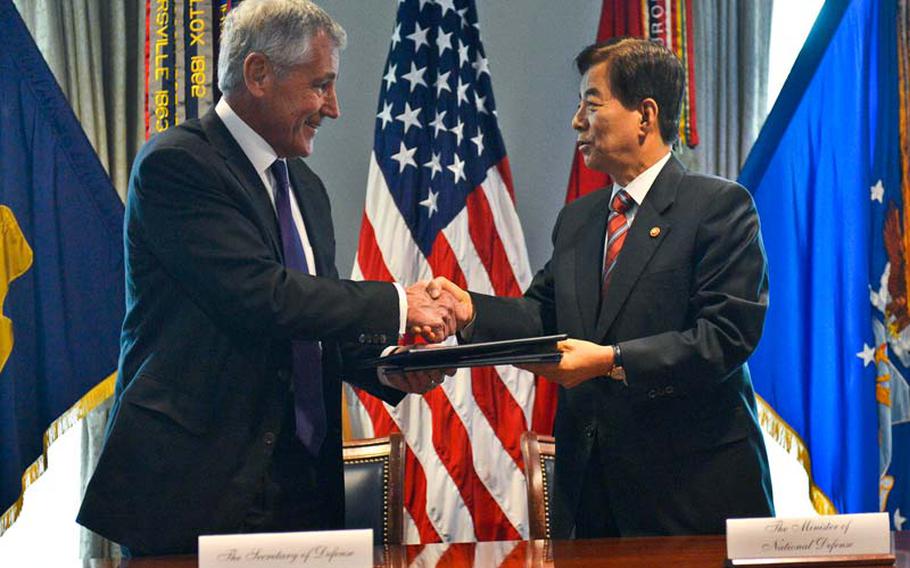 Defense Secretary Chuck Hagel, left, and South Korean defense minister Han Min-koo shake hands at the Pentagon in Washington, D.C., on Thursday, Oct. 23, 2014, after signing a memorandum of understanding that again delays transfer of wartime control over allied forces on the Korean peninsula.