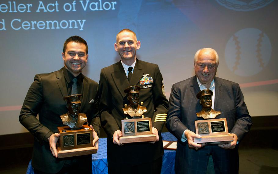 Cleveland Indians first baseman Nick Swisher, left, Senior Chief Petty Officer Carl Thompson and baseball Hall of Famer Tommy Lasorda receive the 2014 Bob Feller Act of Valor Award at the Navy Memorial in Washington D.C., on Nov. 5, 2014.